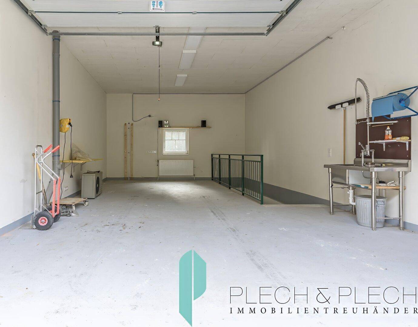 Große Garage mit viel Platz, Werkbank und Fenster für Tageslicht.