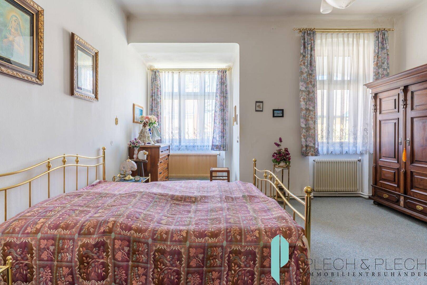 Geräumiges Schlafzimmer mit traditionellem Mobiliar, Doppelbett und viel Tageslicht.