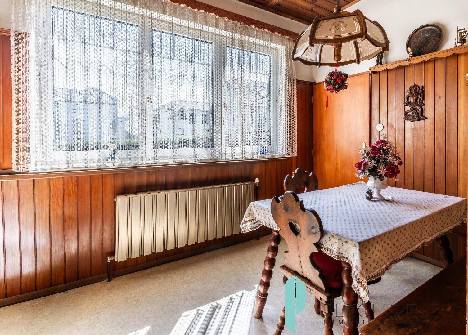 Gemütlicher Essbereich mit Holztisch, Bänken und großen Fenstern für viel Tageslicht.