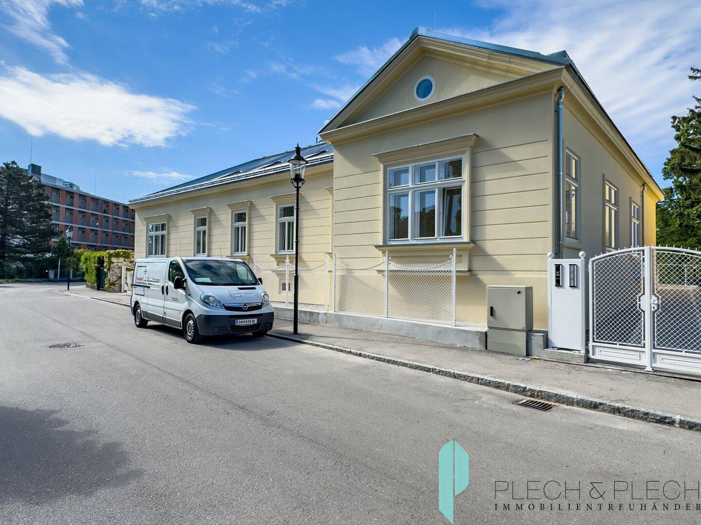Seitenansicht des gelben Gebäudes von der Straße mit einem geparkten Lieferwagen davor.