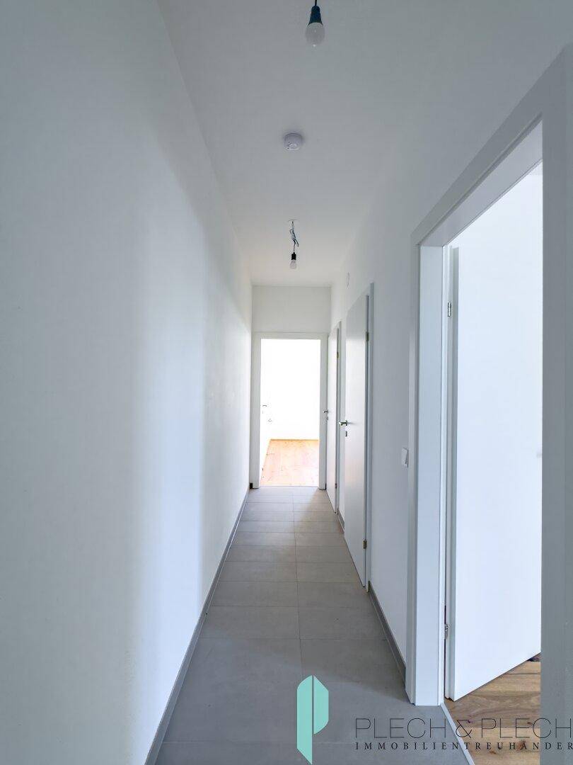 Heller Flur mit Fliesenboden und mehreren Türen, der die verschiedenen Räume der Wohnung verbindet.