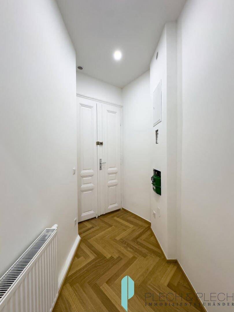 Eingangsbereich mit Fischgrätparkett und klassischer Doppeltür, führt in die Wohnung.
