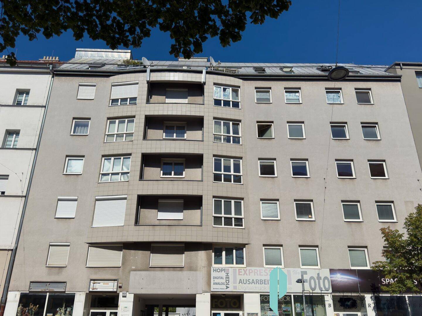 Mehrstöckiges Wohngebäude mit zahlreichen Fenstern und Balkonen in städtischer Umgebung.