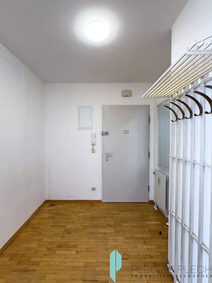 Eingangsbereich mit Parkettboden und Garderobe, der einen freundlichen Empfang in der Wohnung bietet.
