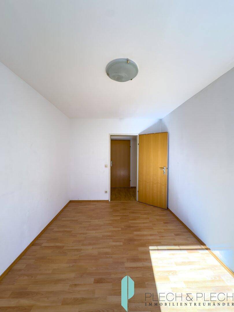 Helles Zimmer mit Parkettboden und weiß gestrichenen Wänden, bereit zur individuellen Gestaltung.