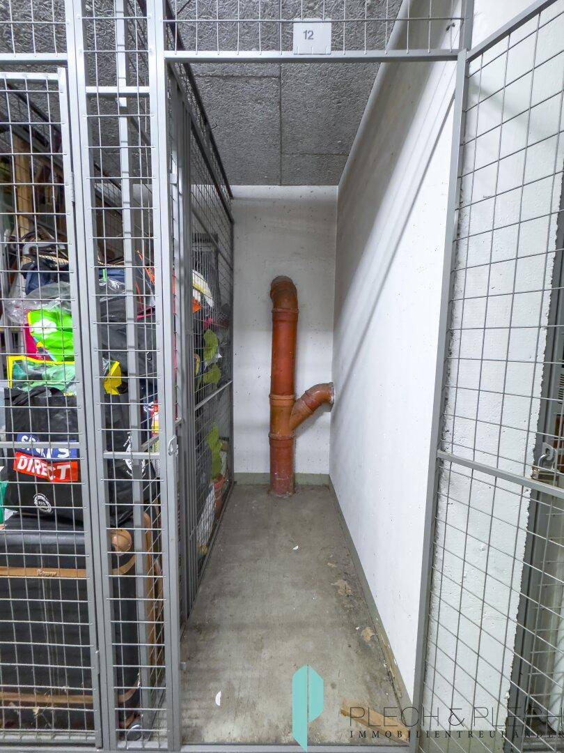 Praktischer Abstellraum im Keller mit Gitterwänden und Stauraum für persönliche Gegenstände.