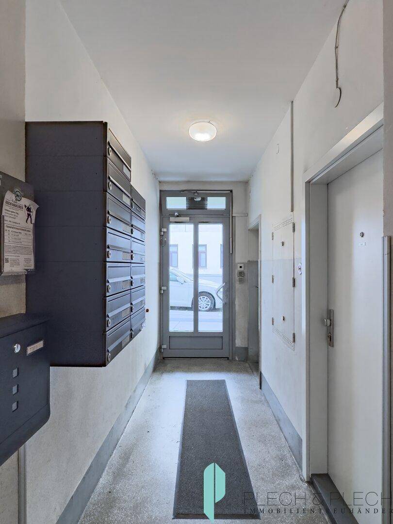 Eingangsbereich des Gebäudes mit Briefkästen und Zugang zur Straße.