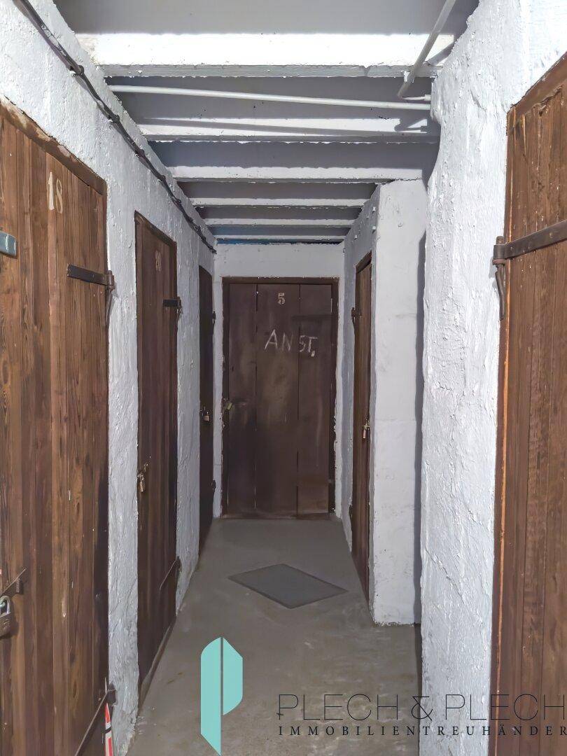 Kellergang mit mehreren Holzabteilen für zusätzlichen Stauraum.