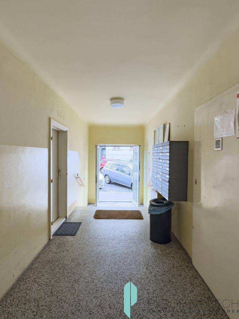 Eingangsbereich des Gebäudes mit Briefkästen und Blick zur Straße.