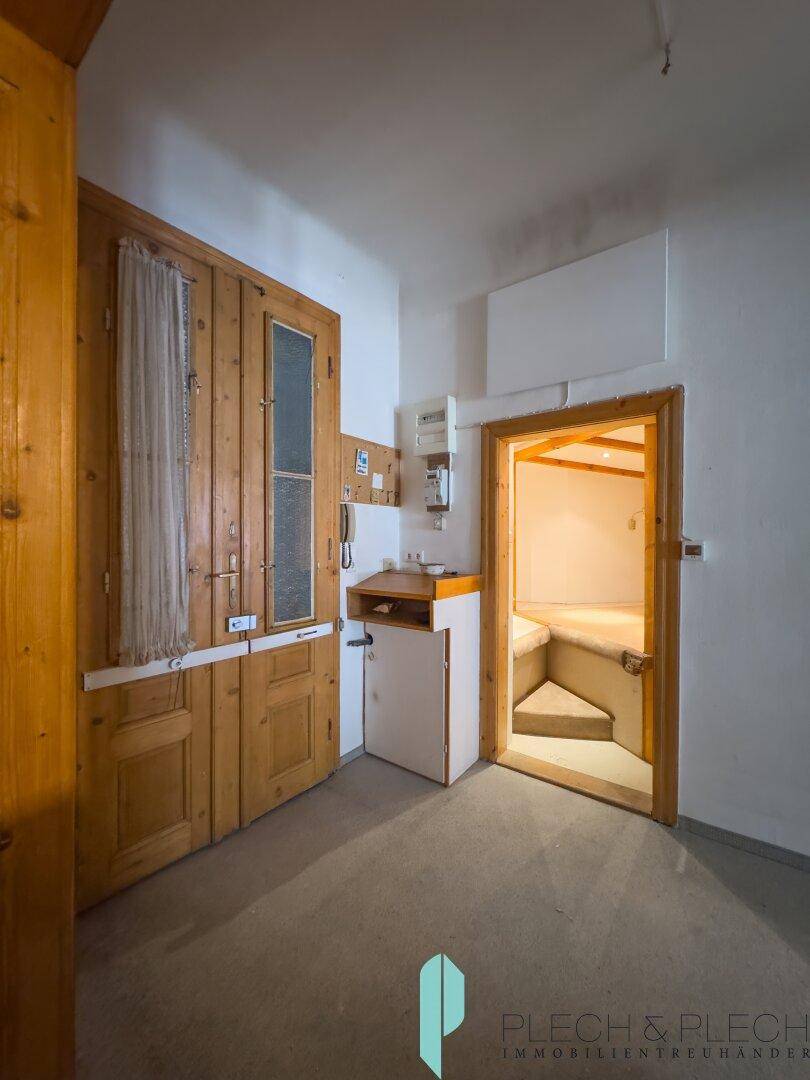 Flur mit Holzverkleidung und Zugang zu einem kleinen Wellnessbereich oder einer Sauna.