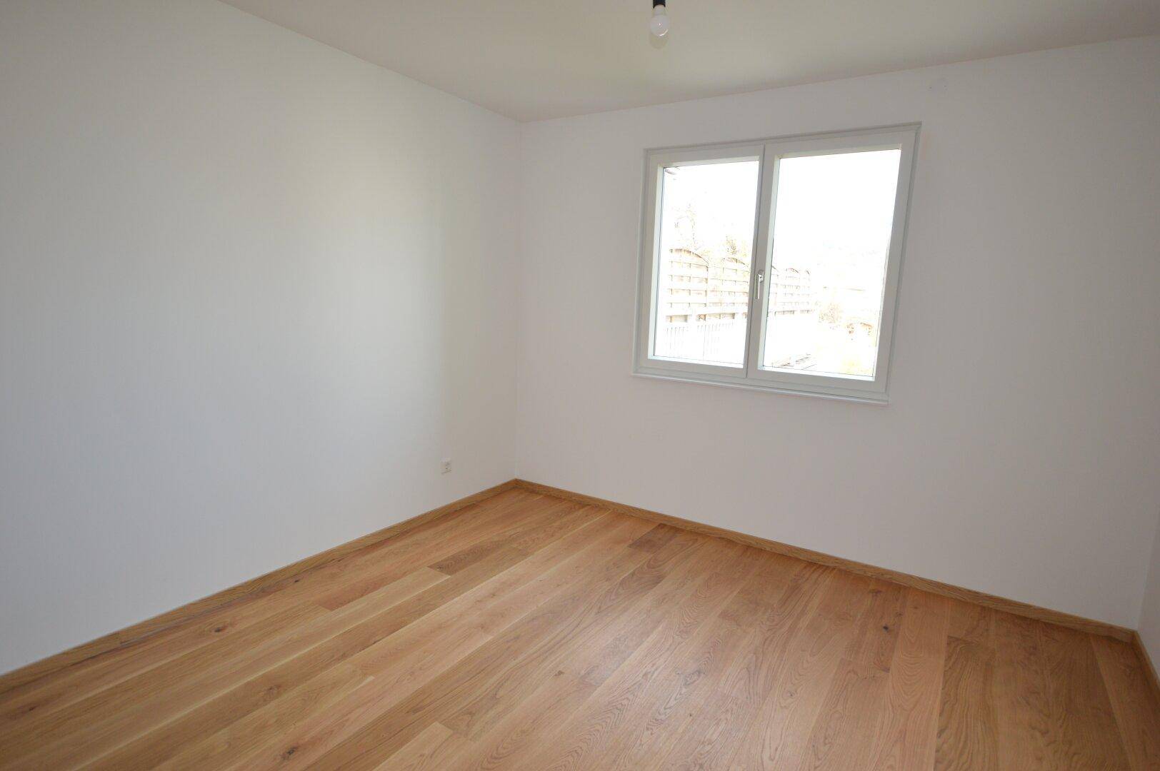 Gemütliches Zimmer mit Holzboden und einem Fenster, ideal als Kinder- oder Arbeitszimmer.