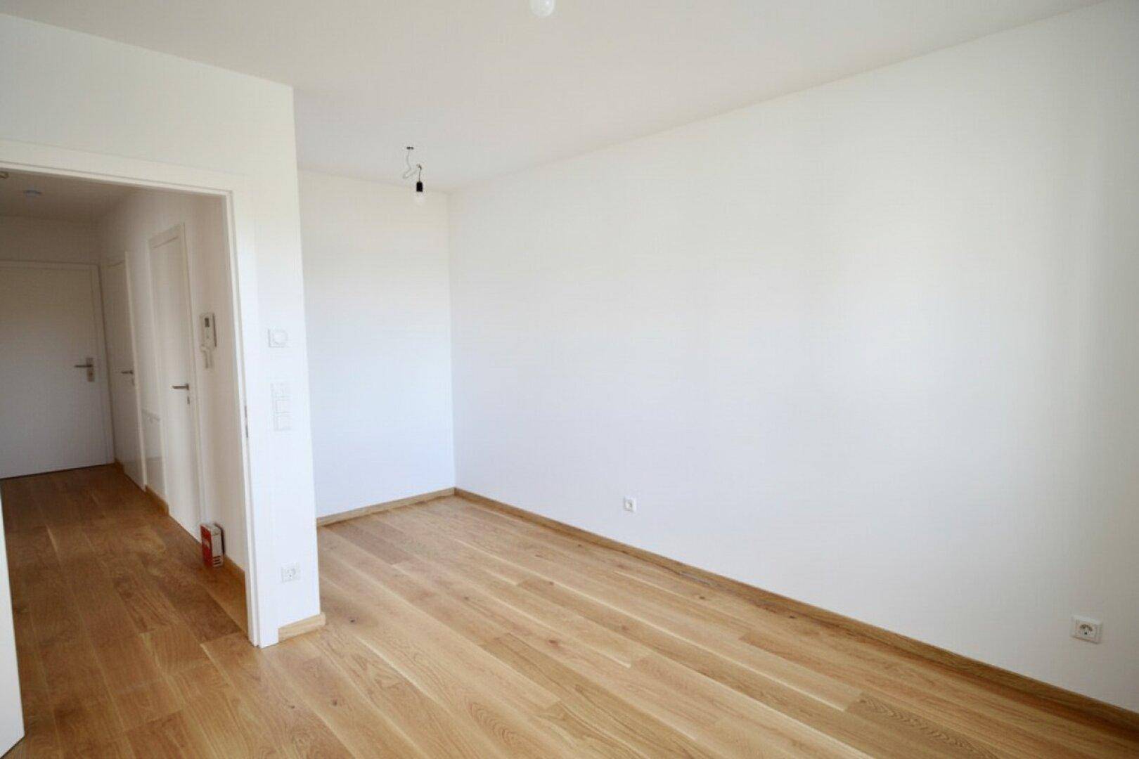 Kompaktes Zimmer mit Parkettboden und Zugang zu einem Flur, vielseitig nutzbar.