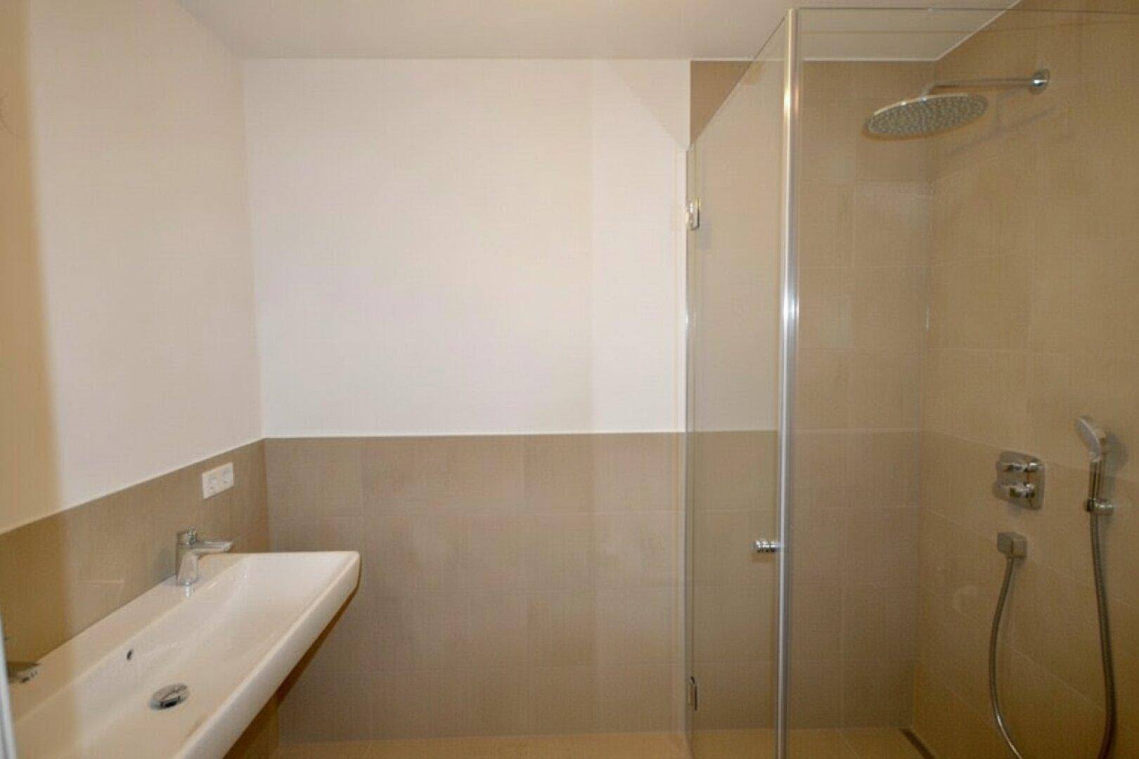 Modernes Badezimmer mit begehbarer Dusche, Regenbrause und eleganten beigefarbenen Fliesen.