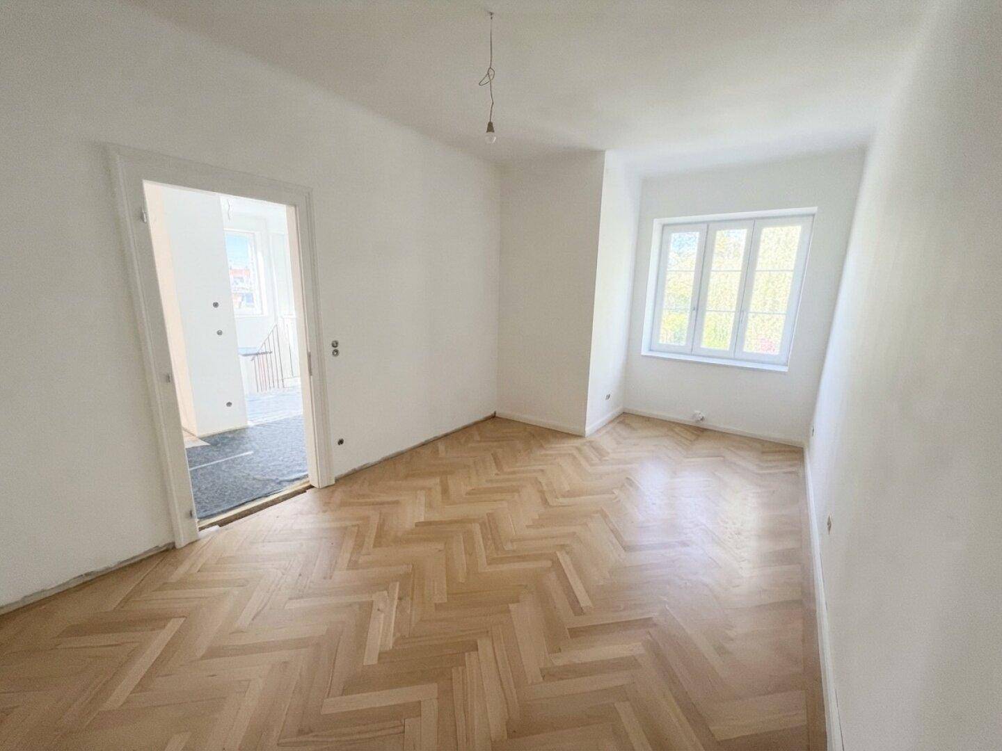 Geräumiges Schlafzimmer mit neuem Fischgrätparkett und weiß gestrichenen Wänden, bereit zum Einzug.