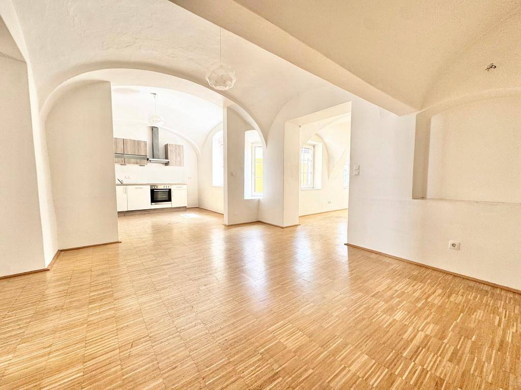 Offener Wohn- und Küchenbereich mit charakteristischen Gewölbedecken und durchgehendem Parkettboden.