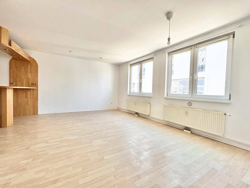 Heller Wohnbereich mit Parkettboden und integrierter Holztheke, ideal für offenes Wohnen.