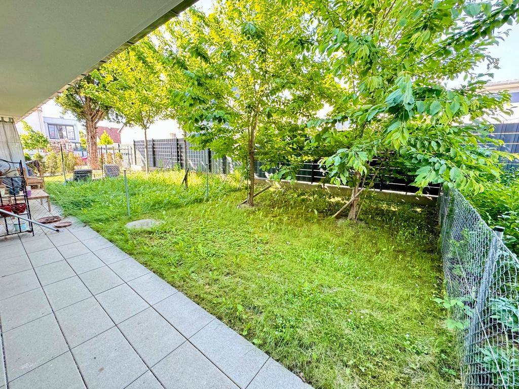 Weitläufiger Gartenbereich mit Rasenfläche und Bäumen, ideal für Entspannung im Freien.