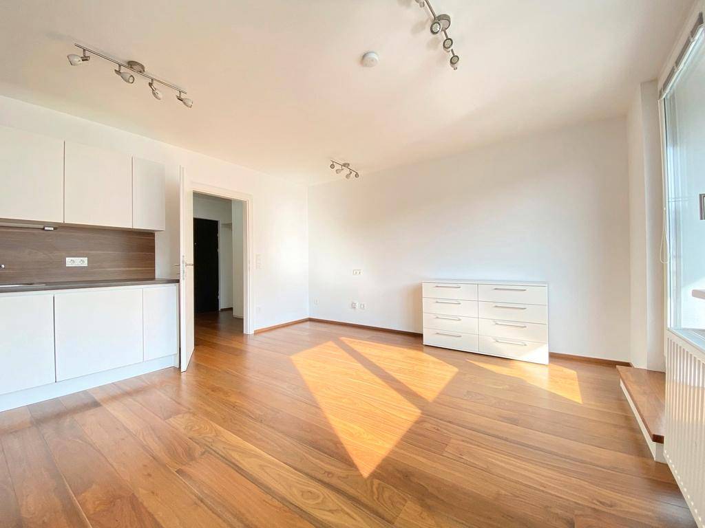 Geräumiger Wohnbereich mit hellem Holzboden und viel Platz für individuelle Einrichtung.