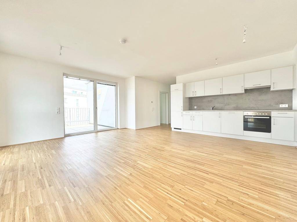 Offener Wohn- und Essbereich mit integrierter Küche und Zugang zur Terrasse.