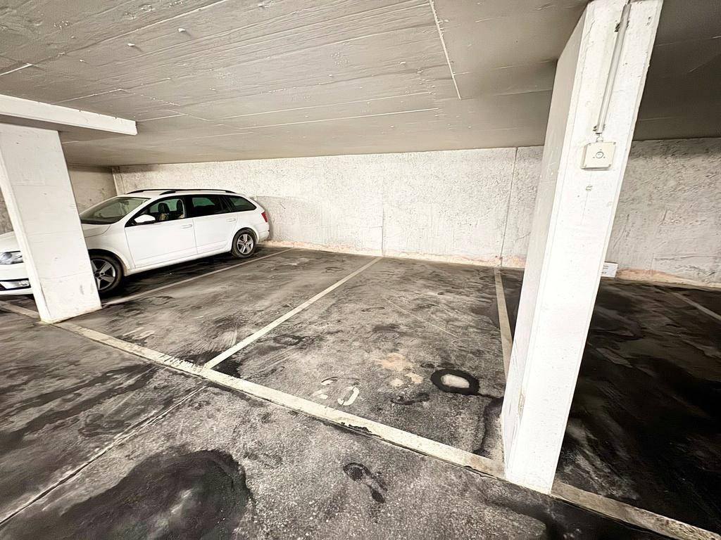 Tiefgarage mit einem geparkten Auto und klaren Markierungen für die Stellplätze.