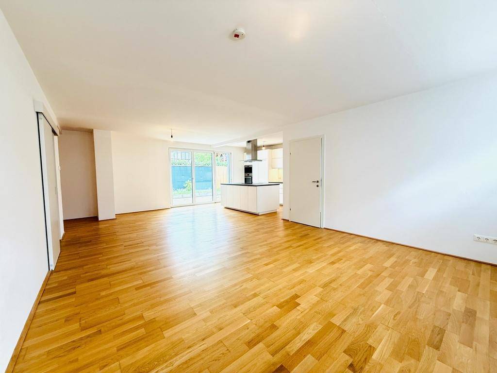 Geräumiger, offener Wohn- und Essbereich mit Parkettboden und viel Tageslicht.