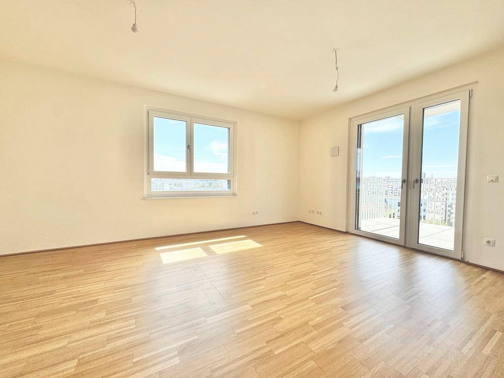 Geräumiger Wohnbereich mit großen Fenstern, die viel Tageslicht hereinlassen und einen weiten Blick bieten.