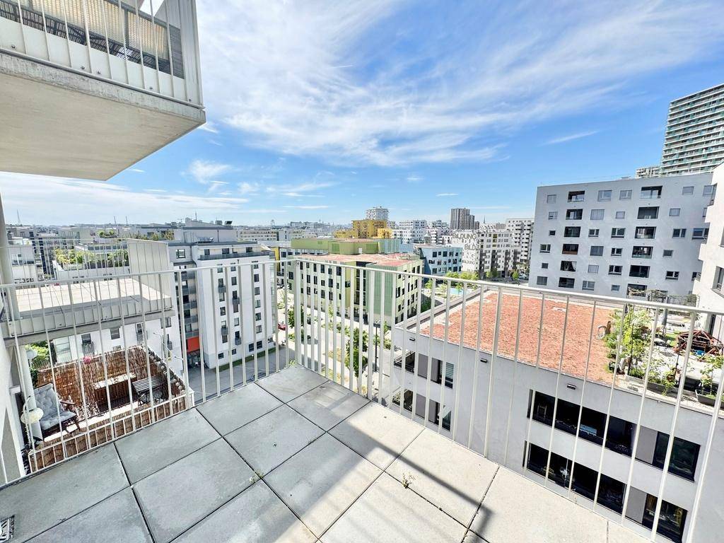 Weitläufiger Ausblick vom Balkon über die Dächer der umliegenden Stadtgebäude und den Horizont.