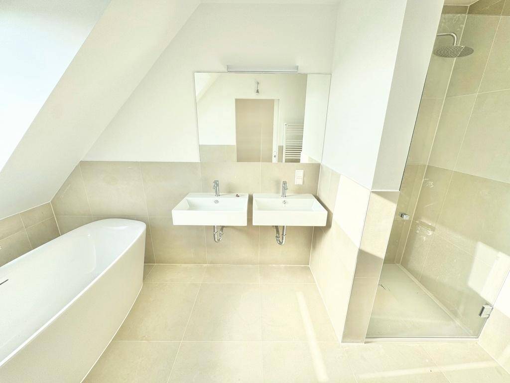 Geräumiges Badezimmer mit Doppelwaschbecken, freistehender Badewanne und großer begehbarer Dusche.