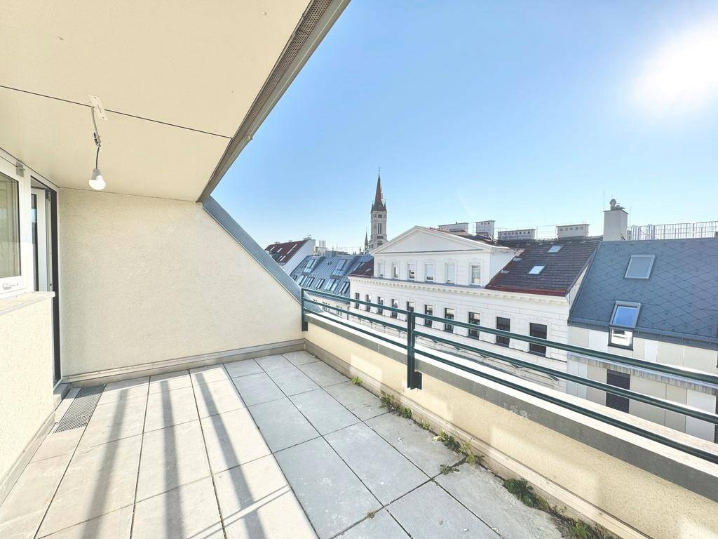 Heller Balkon mit Weitblick über die Stadt und historische Gebäude.