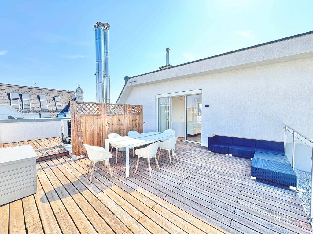 Helle Dachterrasse mit Holzboden, Essbereich und Lounge-Möbeln, mit Zugang zum Innenbereich und Stadtblick.