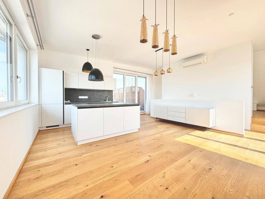 Lichtdurchfluteter Wohnbereich mit integrierter moderner Küche, Holzboden und Klimaanlage für Komfort.