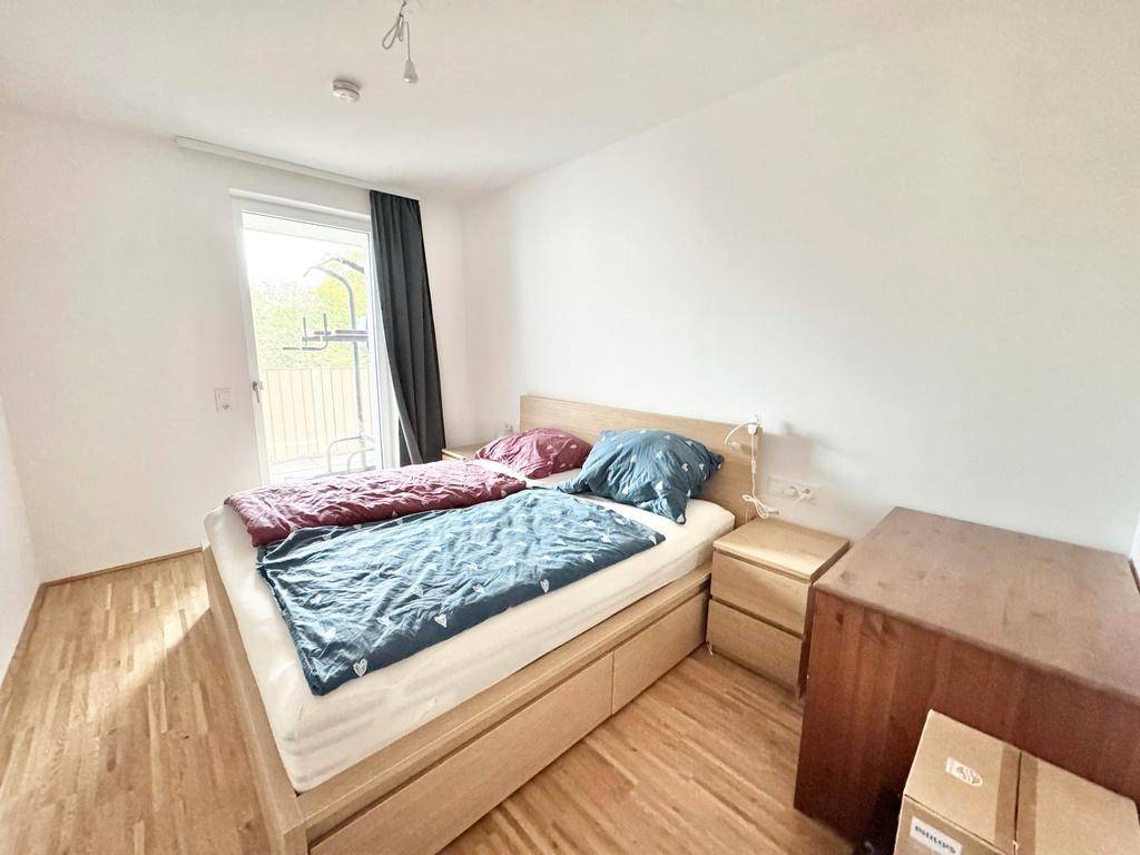 Gemütliches Schlafzimmer mit Doppelbett, Nachttischen und hellem Parkettboden.