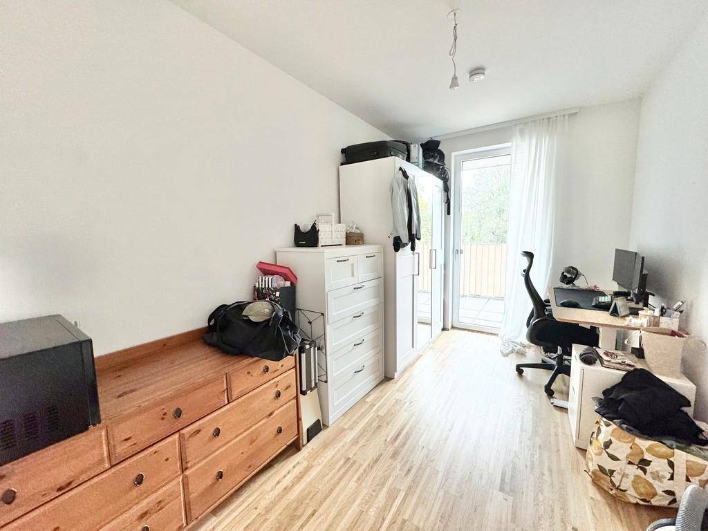 Helles Zimmer mit Parkettboden, Kleiderschrank und Arbeitsbereich, ideal als Schlaf- oder Arbeitszimmer.