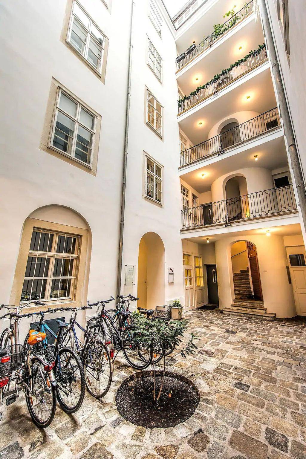 Gepflasterter Innenhof mit Fahrradstellplätzen und Blick auf die Gebäudefassade.