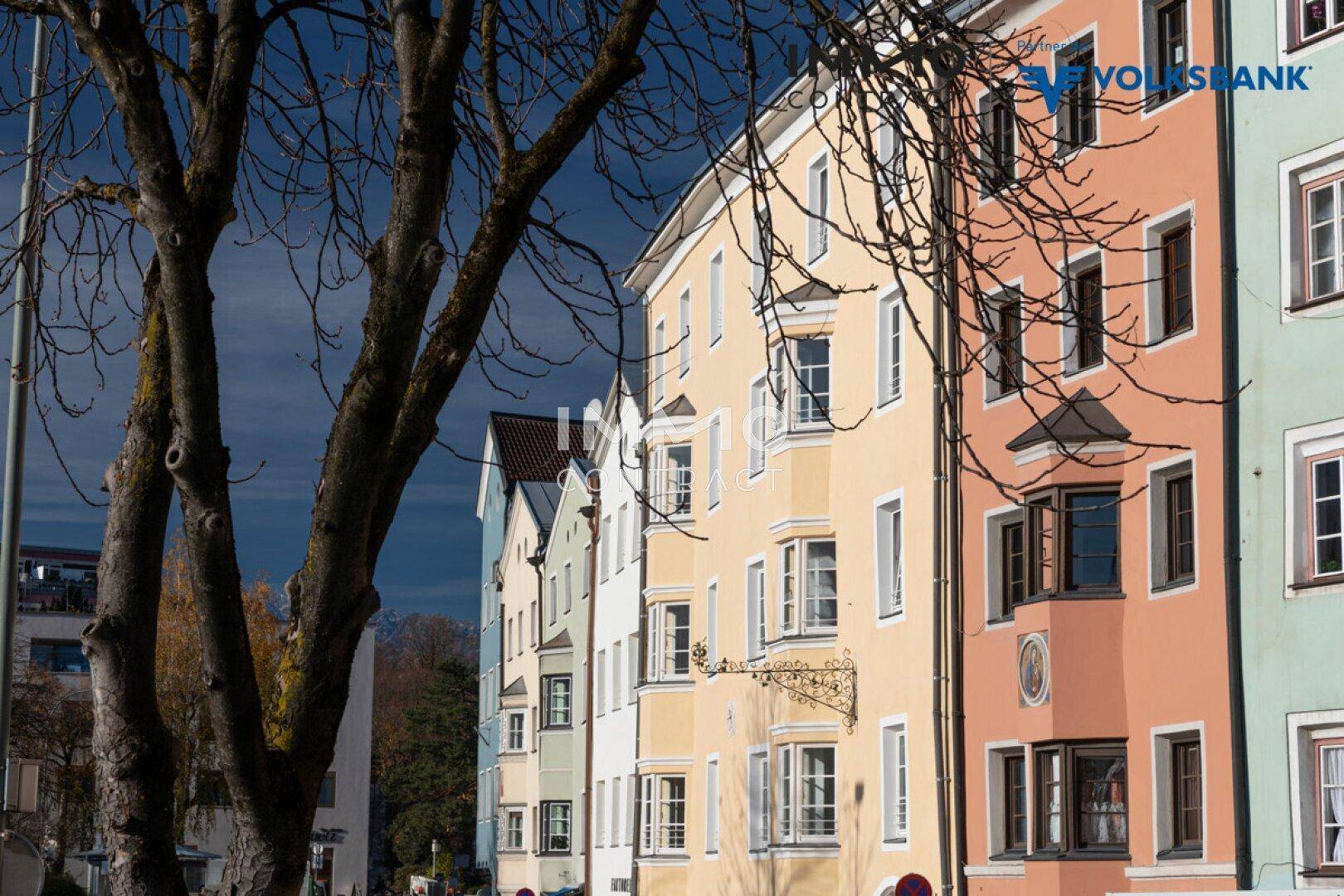 Reihe bunter historischer Gebäude mit Erkerfenstern und traditioneller Architektur an einer städtischen Straße.