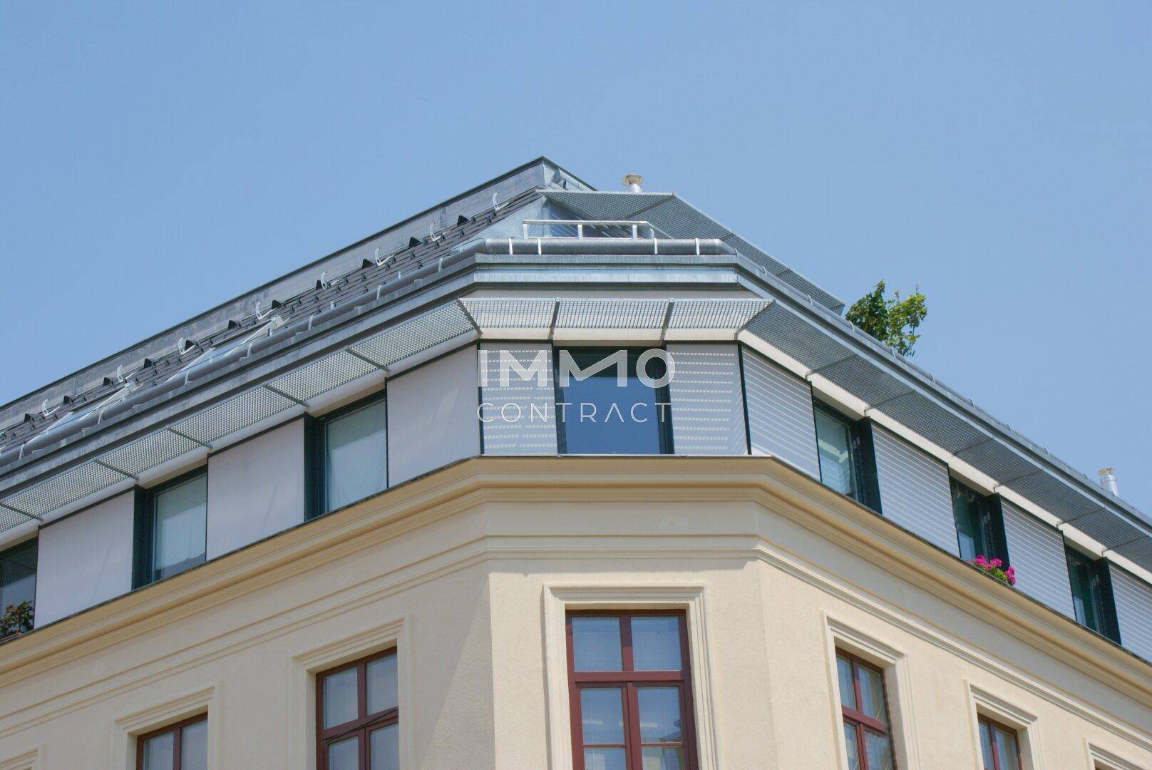 Detailansicht der modernen Dachaufstockung mit großen Fenstern und Außenjalousien.