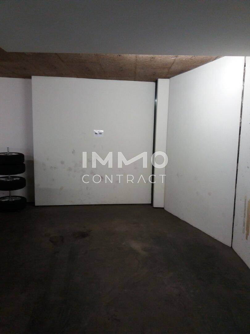 Geräumiger Garagenstellplatz mit Betonboden und Abstellmöglichkeit für Reifen.