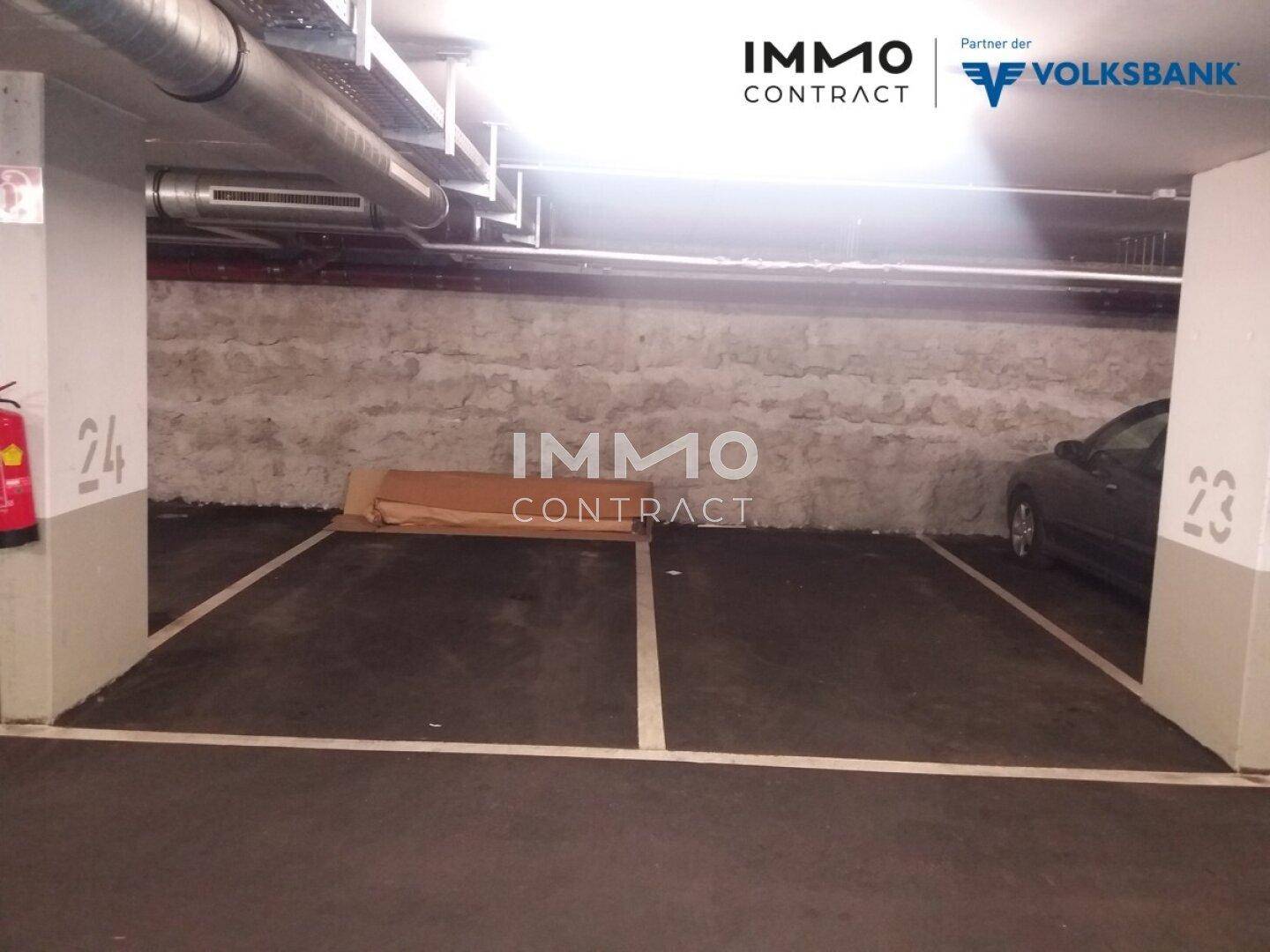 Geräumiger Tiefgaragenstellplatz in einem gepflegten Parkhaus mit Betonwänden und sichtbaren Leitungen.