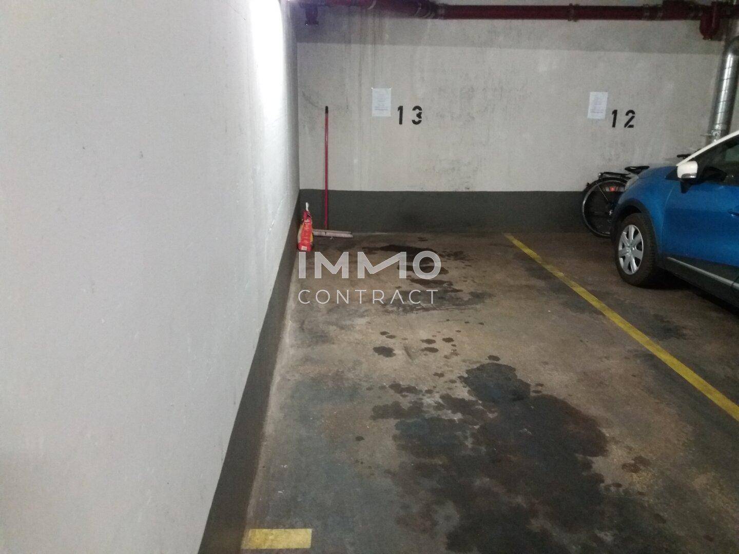 Einzelner Stellplatz in einer Tiefgarage mit Betonboden und sichtbaren Markierungen für Fahrzeuge.