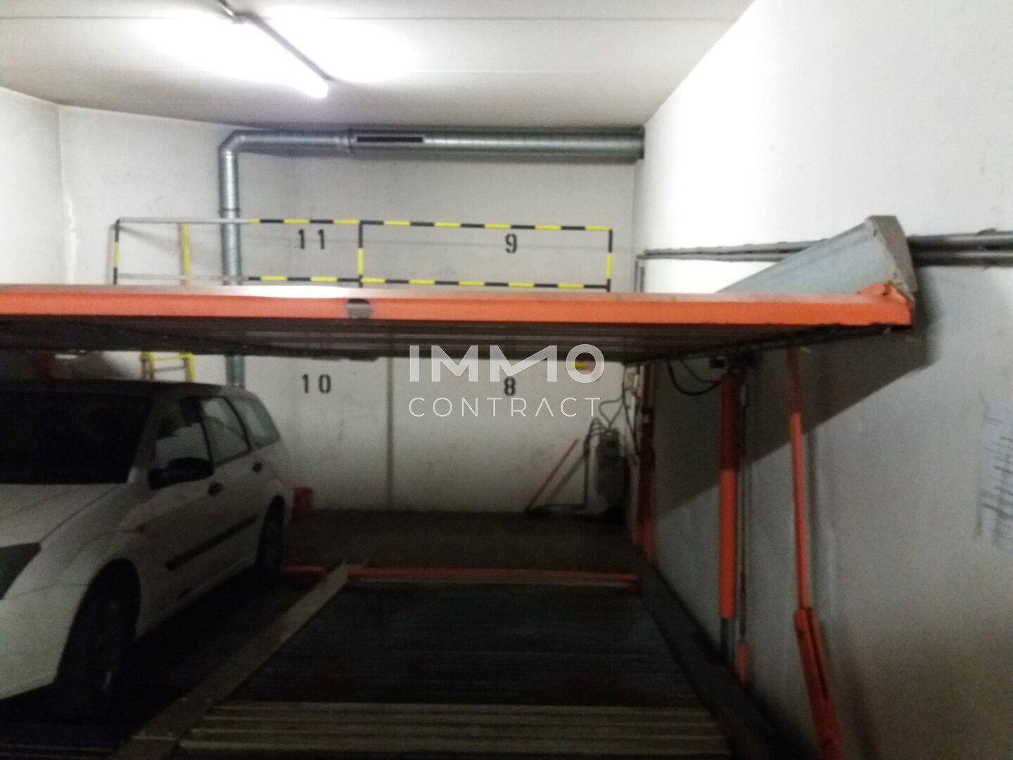 Tiefgarage mit einem mechanischen Parksystem für zwei Fahrzeuge, gut beleuchtet und funktional.