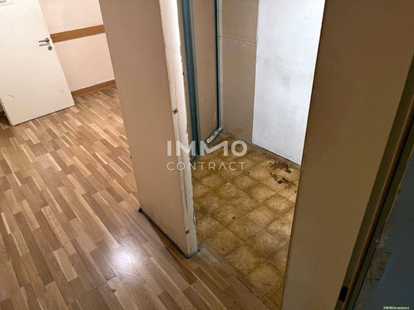 Schmaler Durchgang zu einem Abstellraum mit alten Fliesen und sichtbaren Installationsspuren, der eine Modernisierung erfordert.