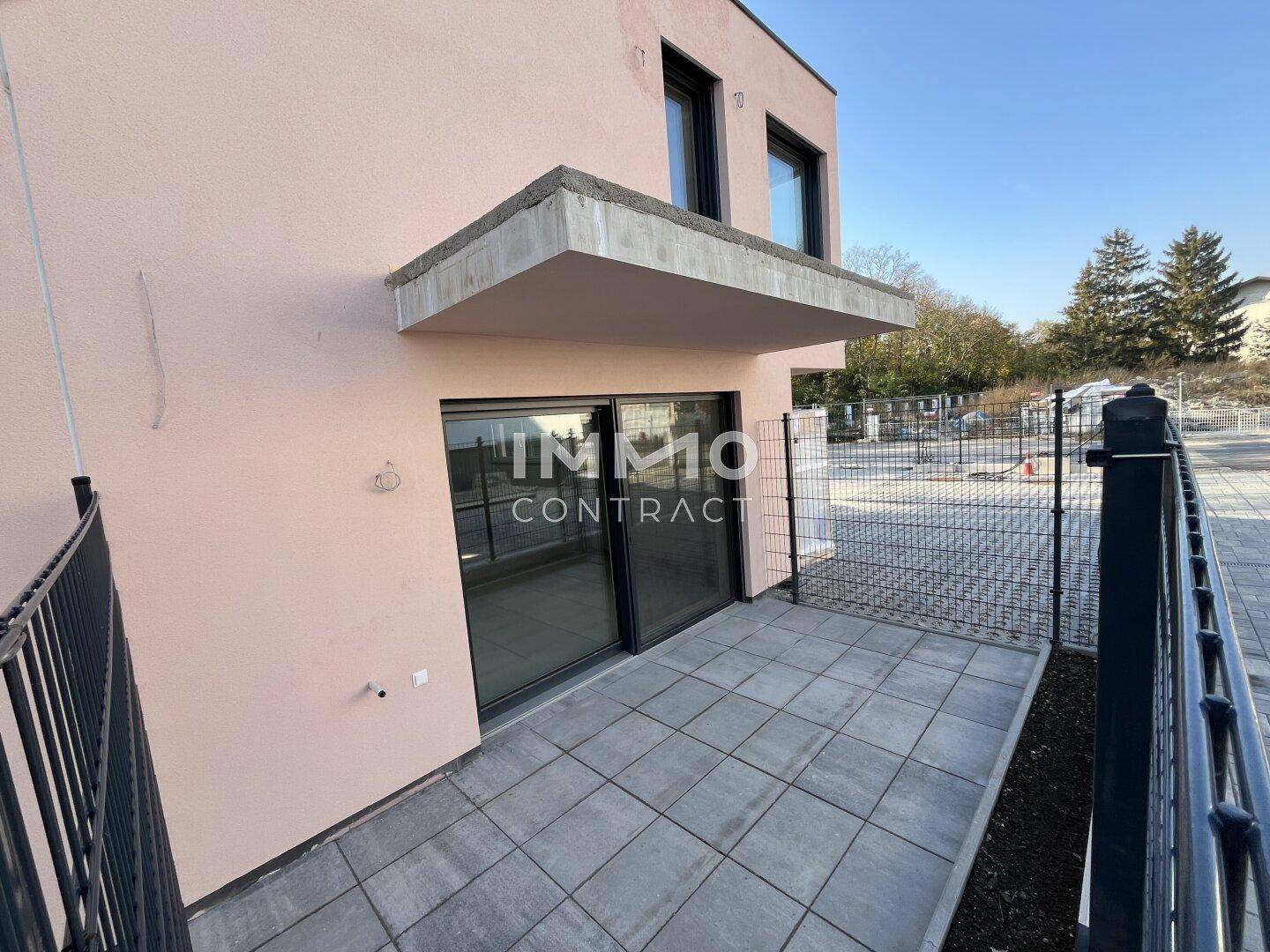 Kleine, gepflasterte Terrasse im Erdgeschoss eines Neubaus mit direktem Zugang zum Innenbereich.