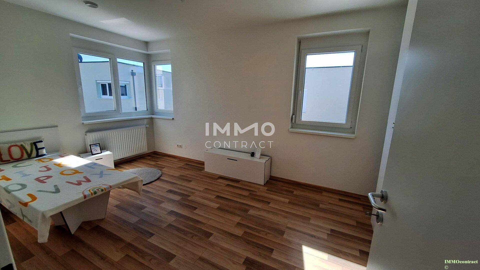 Helles Zimmer mit Laminatboden und großem Fenster, ideal als Kinder- oder Gästezimmer.