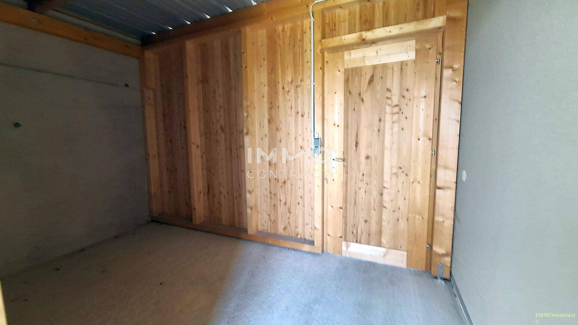 Abstellraum mit Holzwänden, ideal für Gartengeräte oder Fahrräder.