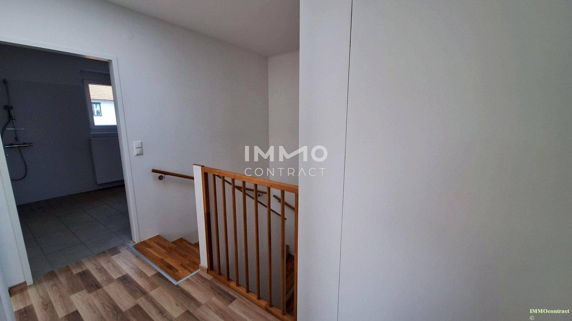 Obergeschoss-Flur mit Holzgeländer und Zugang zum Badezimmer.
