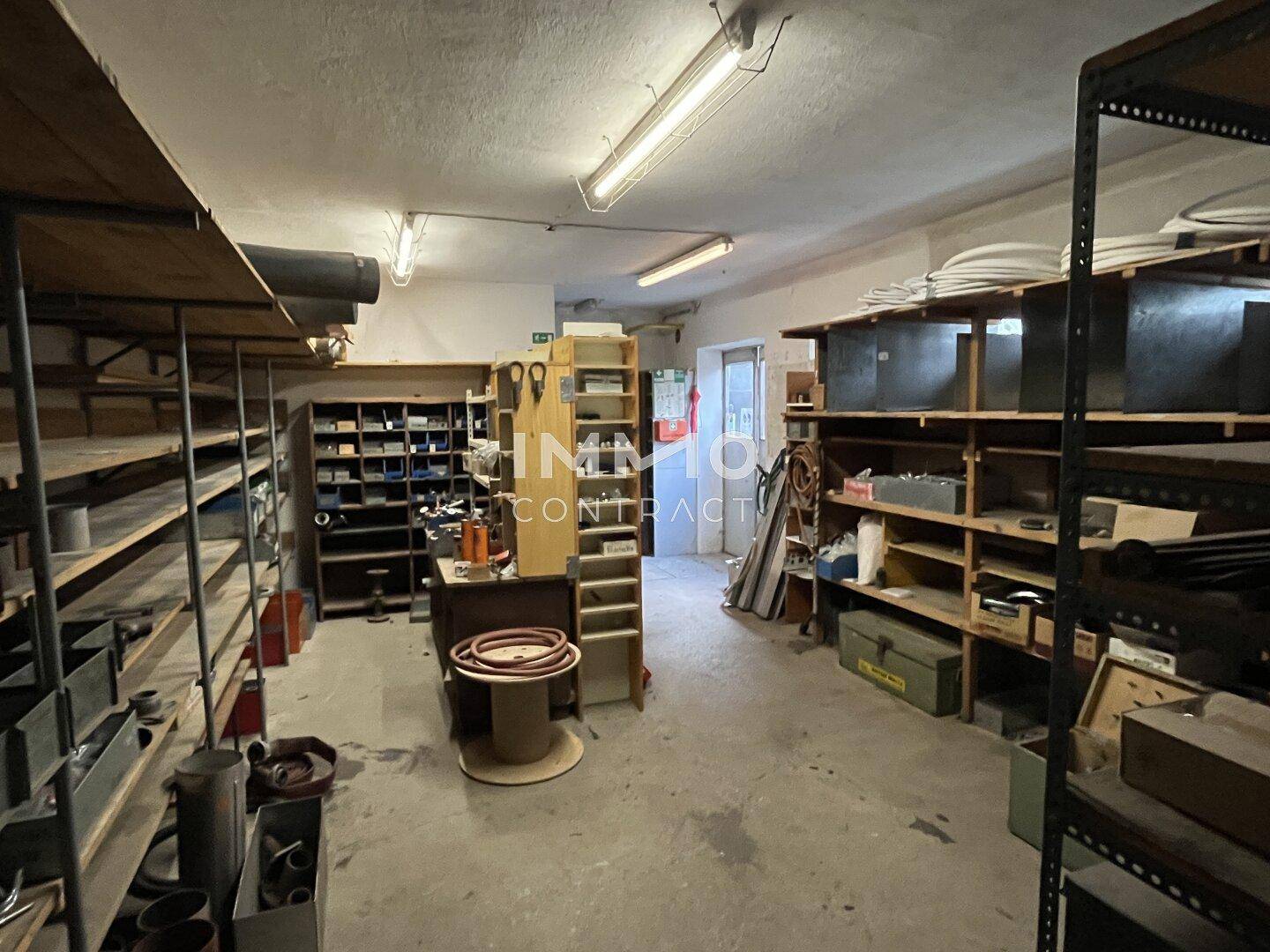 Lagerraum oder Werkstatt mit vielen Regalen, Werkzeugen und Materialien.