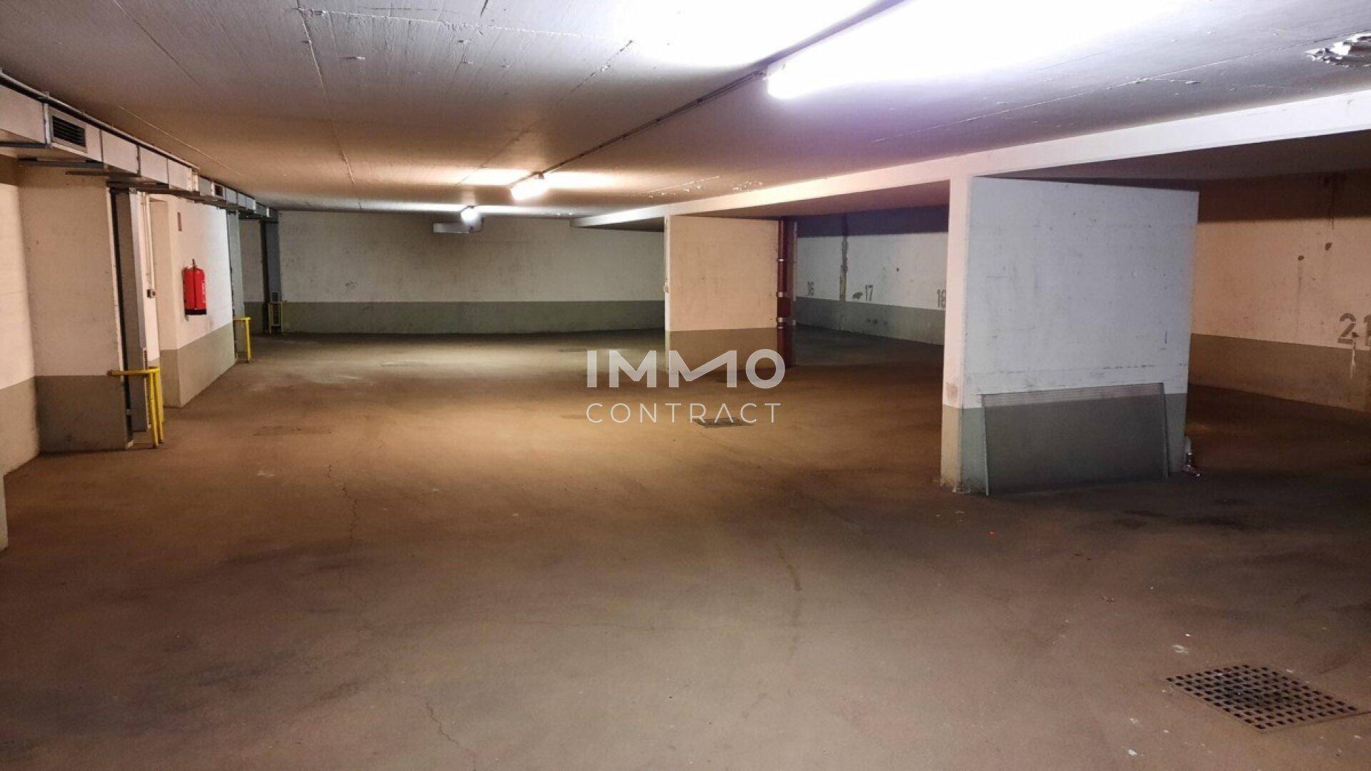 Geräumige Tiefgarage mit vielen freien Stellplätzen, Betonboden und -wänden sowie Brandschutzeinrichtungen.