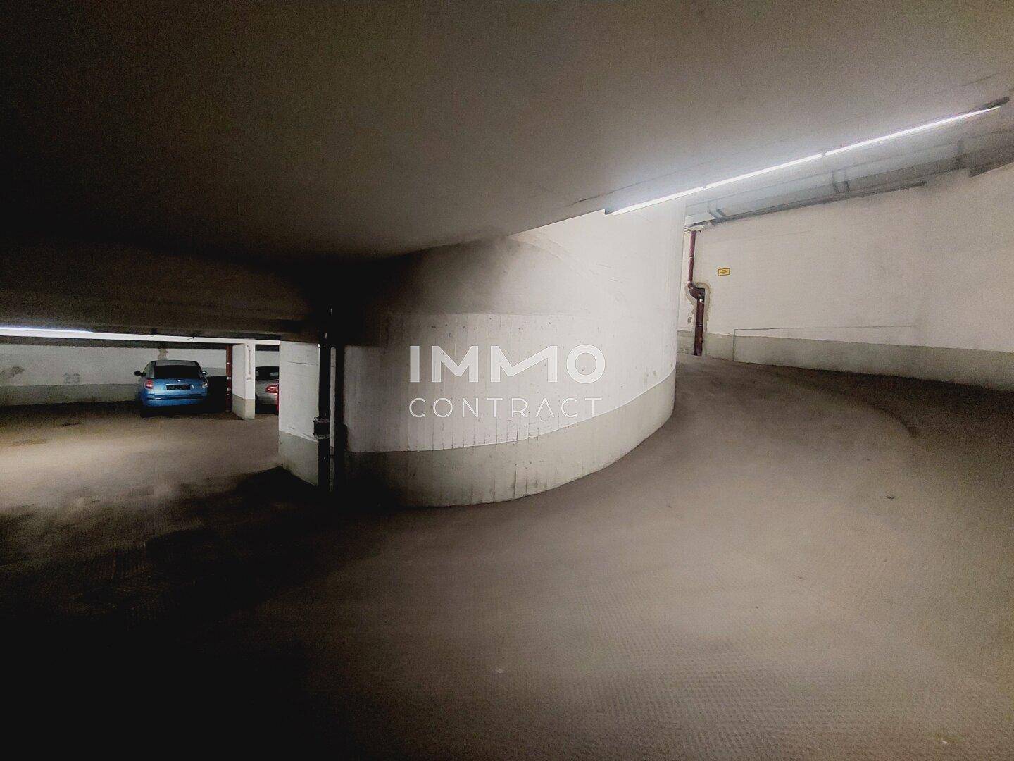 Geschwungene Rampe in der Tiefgarage, die zu weiteren Parkebenen führt und eine einfache Zufahrt ermöglicht.