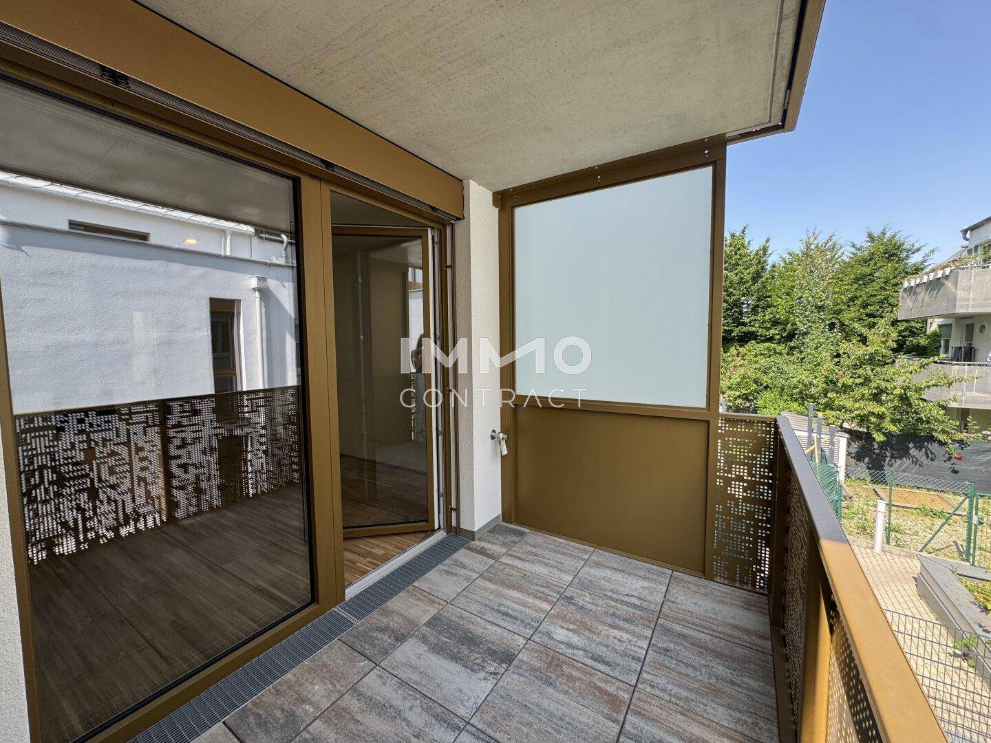 Sonniger Balkon mit Fliesenboden und moderner Metallbrüstung, ideal für entspannte Stunden im Freien.