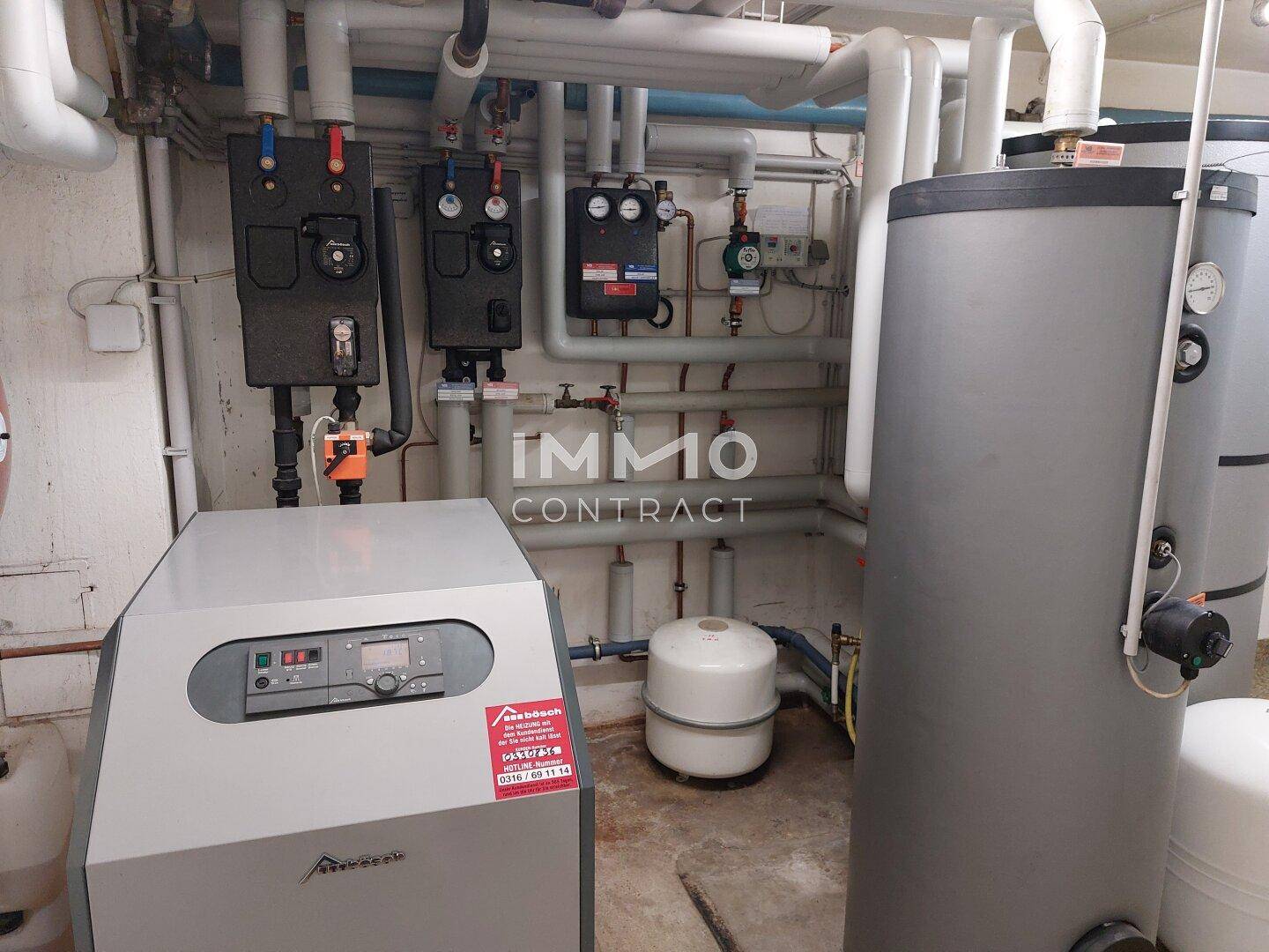 Heizungsraum mit modernen Heizkesseln und Warmwasserspeichern, gut gewartet und funktionsfähig.